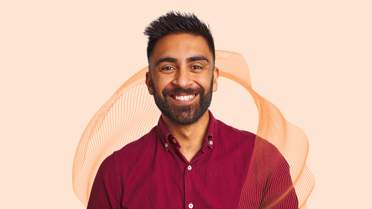A professional man smiles in front of a branded Scrum Alliance background